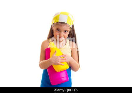 Peu triste fille avec de longs cheveux châtains en chemise jaune et tablier bleu avec mouchoir jaune jaune et rose en bouteilles sur fond blanc dans le stu Banque D'Images