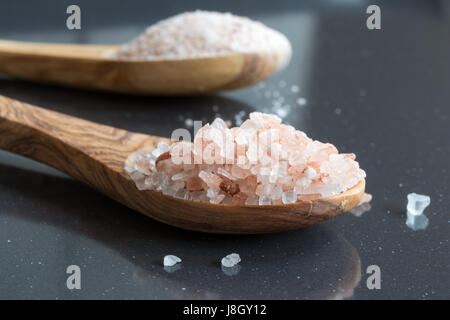 Rough and fine pink Himalayan sea salt on two wooden spoons Banque D'Images