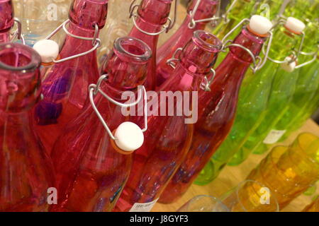 Une collection de bouteilles rose et vert en verre. Banque D'Images