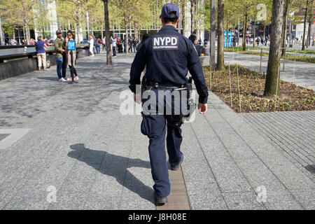 Agent de lutte contre le nypd marche à travers le 9/11 memorial Plaza New York USA Banque D'Images