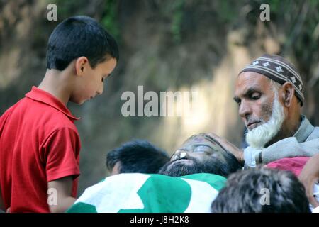 Pulwama, Inde. 28 mai, 2017. (NOTE DU RÉDACTEUR : Image représente la mort) se trouve près de l'enfant un corps mort d'un rebelle tué Subzar Ah Bhat pour offrir des prières funéraires village à Ratsuna, tral dans Pulwama, au sud de Srinagar Subzar Ahmed, âgé de 30 ans, et un adolescent Faizan Ahmed étaient le défunt dans la nuit longue rencontre. Credit : Muneeb ul Islam/Pacific Press/Alamy Live News Banque D'Images