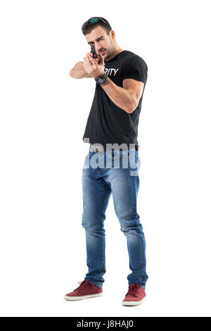 Jeune policier en civil pointing gun avec les deux mains dans le but d'un oeil. La pleine longueur du corps portrait isolé sur fond blanc studio. Banque D'Images