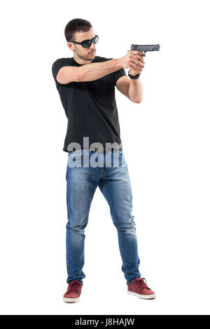 Jeune policier en civil avec des lunettes de vue. des armes à feu Vue de côté. La pleine longueur du corps portrait isolé sur fond blanc studio. Banque D'Images