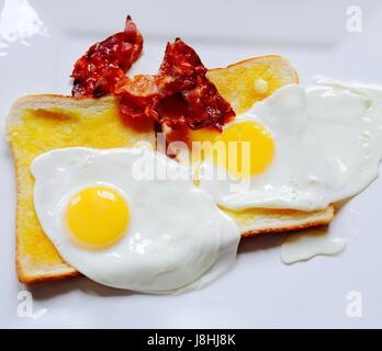 Bacon et d'œufs frits sur toast blanc Banque D'Images