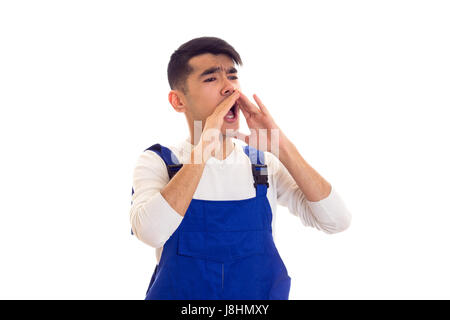 Jeune homme aux cheveux noirs portant en chemise blanche et bleu sur fond blanc criant ensemble en studio Banque D'Images