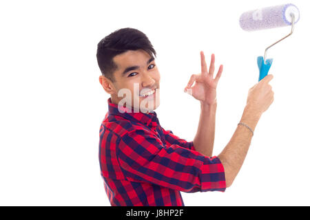 Les jeunes bel homme aux cheveux noirs en chemise à carreaux rouge et bleu à l'aide roll montrant bien sur fond blanc en studio Banque D'Images