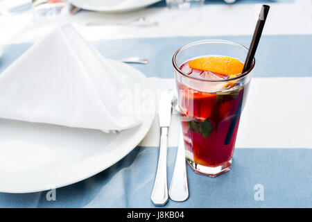 Cocktail limonade rouge vif avec la framboise garnir de citron, de baies et de menthe sur la table Banque D'Images