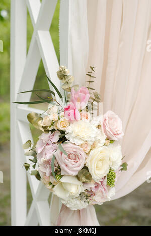 Beautiful wedding arch décoré de tissu beige et de fleurs Banque D'Images