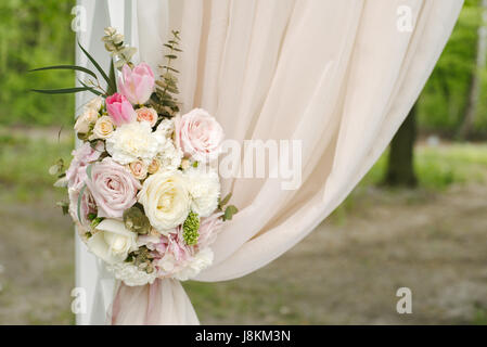 Beautiful wedding arch décoré de tissu beige et de fleurs Banque D'Images