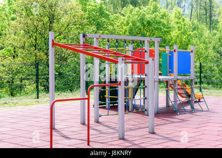 Aire de jeux pour enfants dans un parc public ou à l'extérieur un jardin sur l'arrière-plan d'arbres verts Banque D'Images