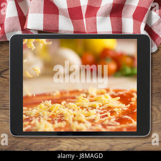Black tablet pc avec pizza affichée sur table en bois et nappe de pique-nique Banque D'Images