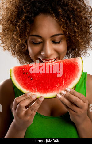 Belle African American Woman olding et manger un fruit pastèque Banque D'Images