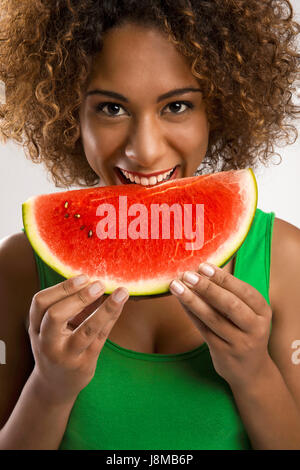 Belle African American Woman olding et manger un fruit pastèque Banque D'Images