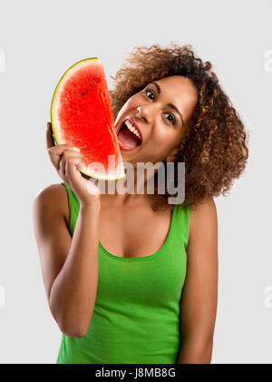 Belle African American Woman olding et manger un fruit pastèque Banque D'Images