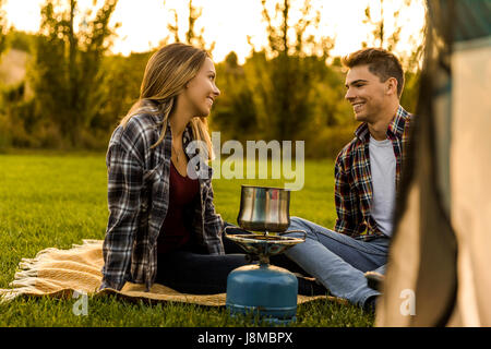 Vue d'un heureux couple camping sur la nature et la cuisson Banque D'Images