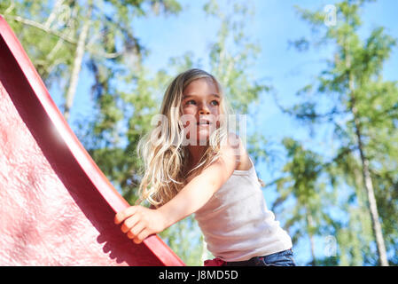 Les jeunes actifs enfant mignon girl in aire sur la diapositive sur une belle journée d'été. Activités d'été pour enfants. Banque D'Images