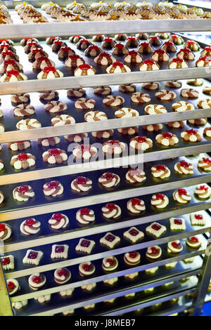 Biscuits et Gâteaux sur des étagères métalliques dans une usine de confiserie Banque D'Images