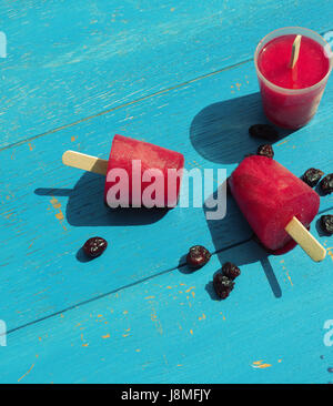 Trois glaces maison douce pop sur une table de jardin bleu vintage, dans les tons de couleur Banque D'Images