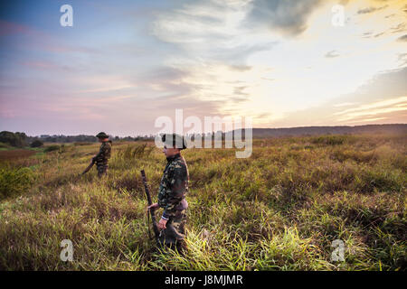 Choisir de bons chasseurs pour la chasse aux canards dans les régions rurales de champ pendant beau lever de soleil. Banque D'Images