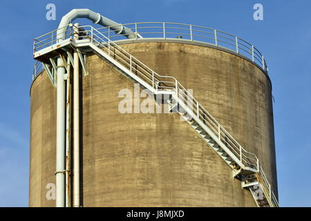 Cylindriques en béton avec silo industriel metal escalier avec garde-corps de sécurité et de grand alésage des tuyaux. Banque D'Images