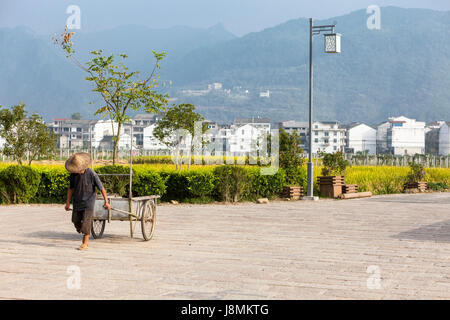 Cangpo, Zhejiang, Chine. Panier tirant villageois, en fin d'après-midi. Banque D'Images