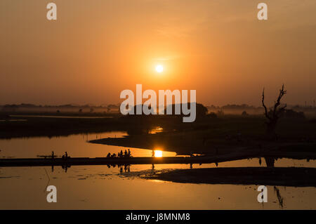 Silhouettes de personnes sur le lac Taungthaman au coucher du soleil, à Amarapura, Mandalay, Myanmar