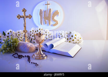 La première Communion. Thème de la religion catholique. Crucifix, Bible, pain isolé sur fond blanc et de table blanc. Banque D'Images