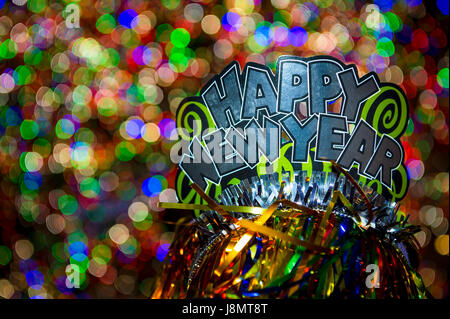 Happy New Year party hat sparkling contre un appartement de célébration Contexte en une nuit Banque D'Images