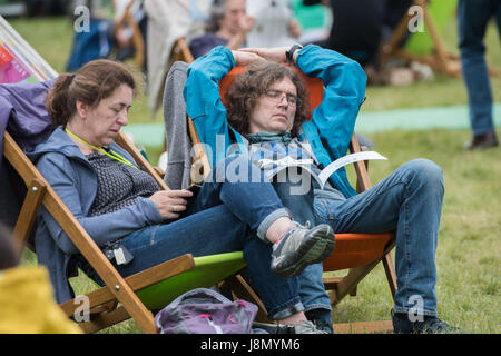 Hay Festival, au Pays de Galles, Royaume-Uni Lundi 29 mai 2017 Les gens se détendre dans le coloré de chaises longues sur la pelouse par une chaude et humide de la Banque lundi après-midi, à l'Hay Festival de littérature 2017 Maintenant dans sa 30e année, le festival attire des dizaines de milliers de visiteurs par jour pour ce qui a été décrit par l'ancien président américain Bill Clinton comme "le Woodstock de l'esprit' Crédit photo Credit : Keith morris/Alamy Live News Banque D'Images