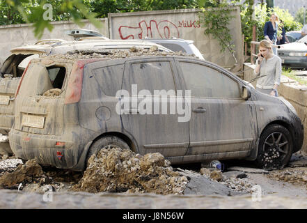 Kiev, Ukraine. 29 mai, 2017. Une fille regarde une voiture endommagée, à l'emplacement d'un accident de pipeline d'eau à Kiev, Ukraine, le 29 mai 2017. Plusieurs voitures et des fenêtres d'un immeuble ont été endommagés par des morceaux d'asphalte et le sol par la pression de l'eau, à la cause d'un accident de pipeline à Kiev. Crédit : Serg Glovny/ZUMA/Alamy Fil Live News Banque D'Images