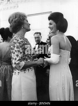 Madame Nicole Alphand, épouse de l'ambassadeur aux États-Unis Hervé Alphand à partir de la France, gauche, et de la première dame Jacqueline Bouvier Kennedy, droite, admirer leurs robes comme ils discutèrent ensemble lors d'un dîner à l'Ambassade de France avant l'ouverture de l'exposition de la Joconde à la National Gallery of Art de Washington, DC, le 8 janvier 1963. Mme Alphand et Mme Kennedy ont été nommés deux des dix meilleures femmes habillées en Amérique. Credit : Arnie Sachs / CNP /MediaPunch Banque D'Images