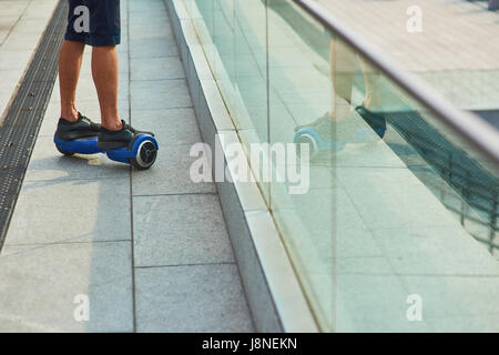 Jambes d'hommes sur hoverboard. Banque D'Images