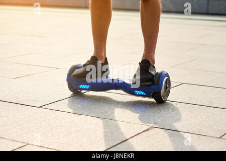 Les jambes de l'homme sur l'hoverboard. Banque D'Images