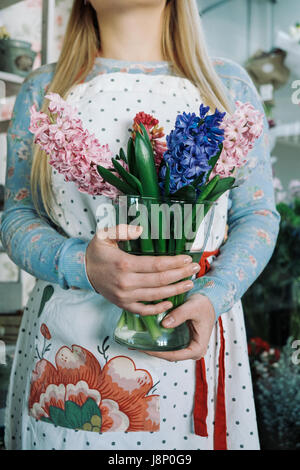 Fleuriste femme holding bouquet de fleurs de jacinthe dans l'intérieur. close up Banque D'Images