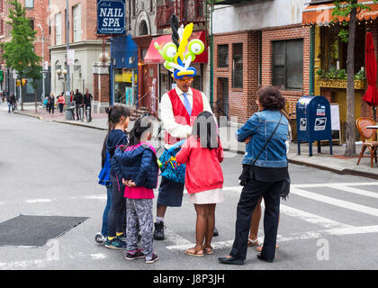 L'homme la fabrication et la vente des animaux avec des ballons dans une rue de Manhattan, NYC Banque D'Images