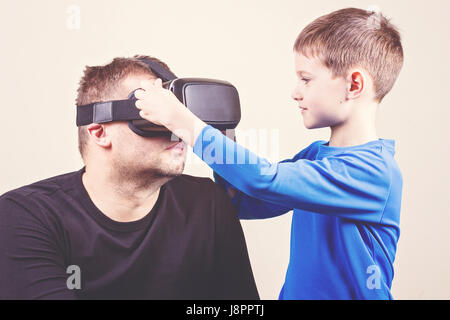 Père et fils essayer lunettes VR. Banque D'Images