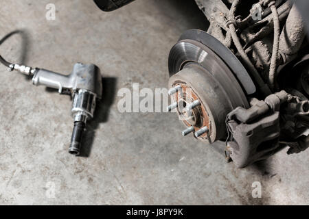Frein à disque libre du véhicule pour réparation. tourné la roue, l'outil pour desserrer les écrous des vis internes. Banque D'Images
