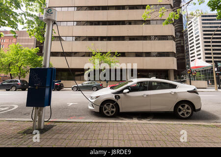 Montréal, CA - 27 mai 2017 : Chevrolet Volt voiture électrique branché sur une station de recharge EV dans le centre-ville de Montréal Banque D'Images