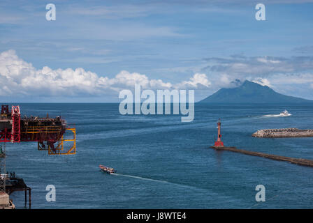 Vue sur la baie de Manado avec le mont Manado Tua au premier plan d'un phare et d'une partie d'un pont en construction à Manado, en Indonésie. Banque D'Images