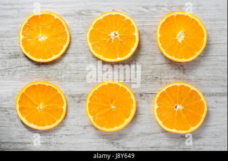 Six tranches d'oranges fraîches sur fond de bois blanc Banque D'Images