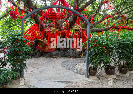 Guilin, Chine. Elephant Trunk Hill Park. Rubans rouges accrochés sur arbre, demandant un souhait pour la nouvelle année. Phoenix chinois dans le centre. Banque D'Images