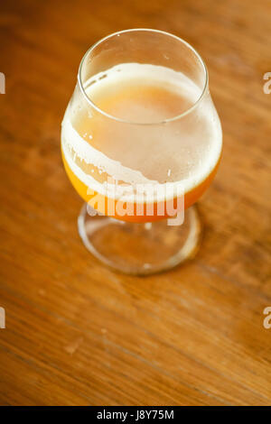 Verre de bière de blé debout sur un tonneau en bois dans une brasserie Banque D'Images