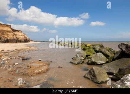 La plage à Happisburgh à Norfolk, Angleterre Royaume-uni montrant les débris des maisons qui sont tombés de la falaise en raison de l'érosion Banque D'Images