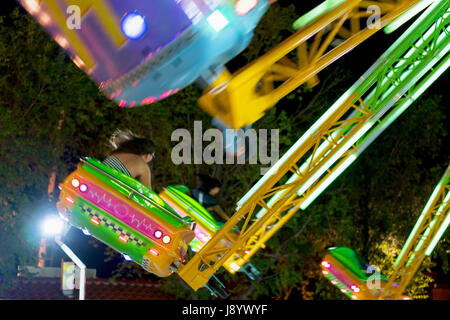 Carousel sur chaînes roulant avec une grande vitesse dans la nuit, Omis, Croatie. Focus sélectif. Motion Blur Banque D'Images