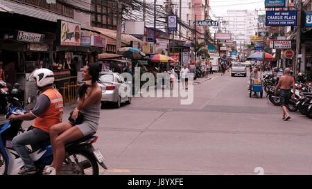 Fille sur l'arrière de moto en circulation à soi et soi Buakhao Pattaya Thailande Diana Intersection la plus dangereuse sur un jour nuageux sombre Banque D'Images