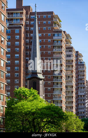 Le clocher d'église des Saints Apôtres contrastant avec la construction de terrasses sud Penn à Chelsea en été. Manhattan, New York City Banque D'Images