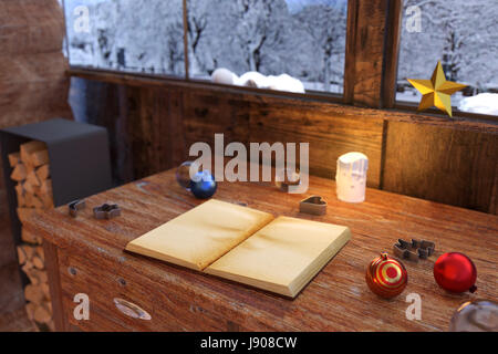 Le rendu 3D de livre ouvert sur la table en bois vintage à maison en bois avec décoration de Noël Banque D'Images