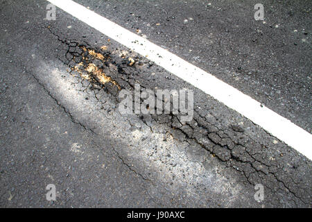 Asphalte fissuré de route avec double white lines Banque D'Images