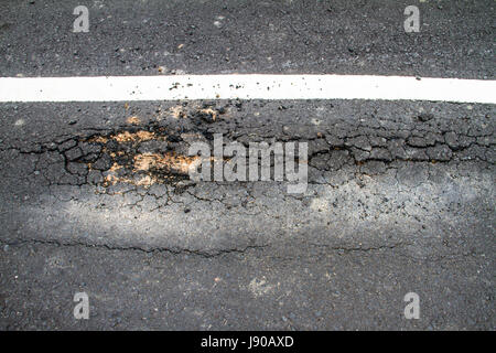 Asphalte fissuré de route avec double white lines Banque D'Images