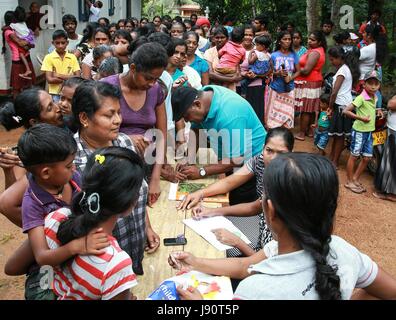 (170531) -- YABARALUWA (SRI LANKA), 31 mai 2017 (Xinhua) -- les résidents locaux à attendre en ligne pour recevoir des secours donnés par des machines de la Chine Engineering Corporation dans Yabaraluwa village près de Colombo, Sri Lanka, le 30 mai 2017. Les ressortissants chinois et les entreprises au Sri Lanka ont commencé les dons pour aider des milliers de victimes qui ont été touchées par de graves inondations et glissements de terrain. (Xinhua/Huang Haimin) (hy) Banque D'Images